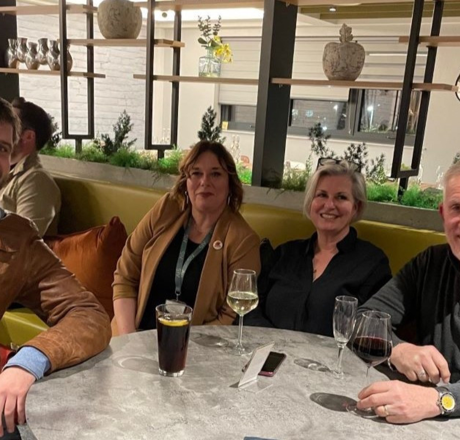 group of people sat around a table drinking