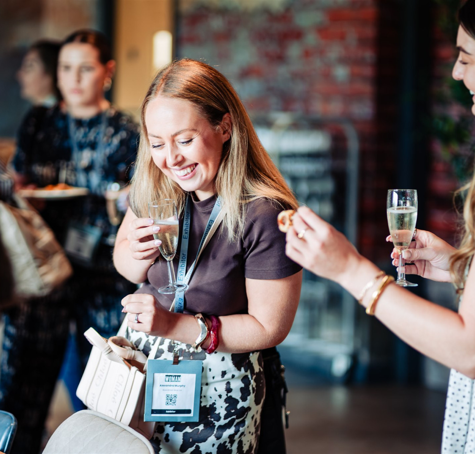 two women laughing at a drinks reception