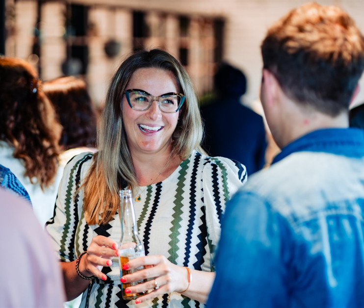 woman laughing whilst holding drinks bottle
