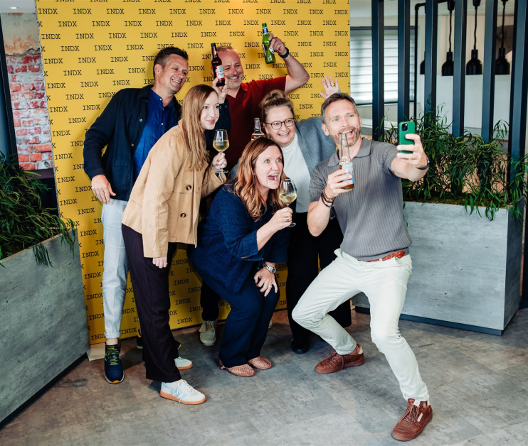 group of people taking a selfie in front of yellow backdrop