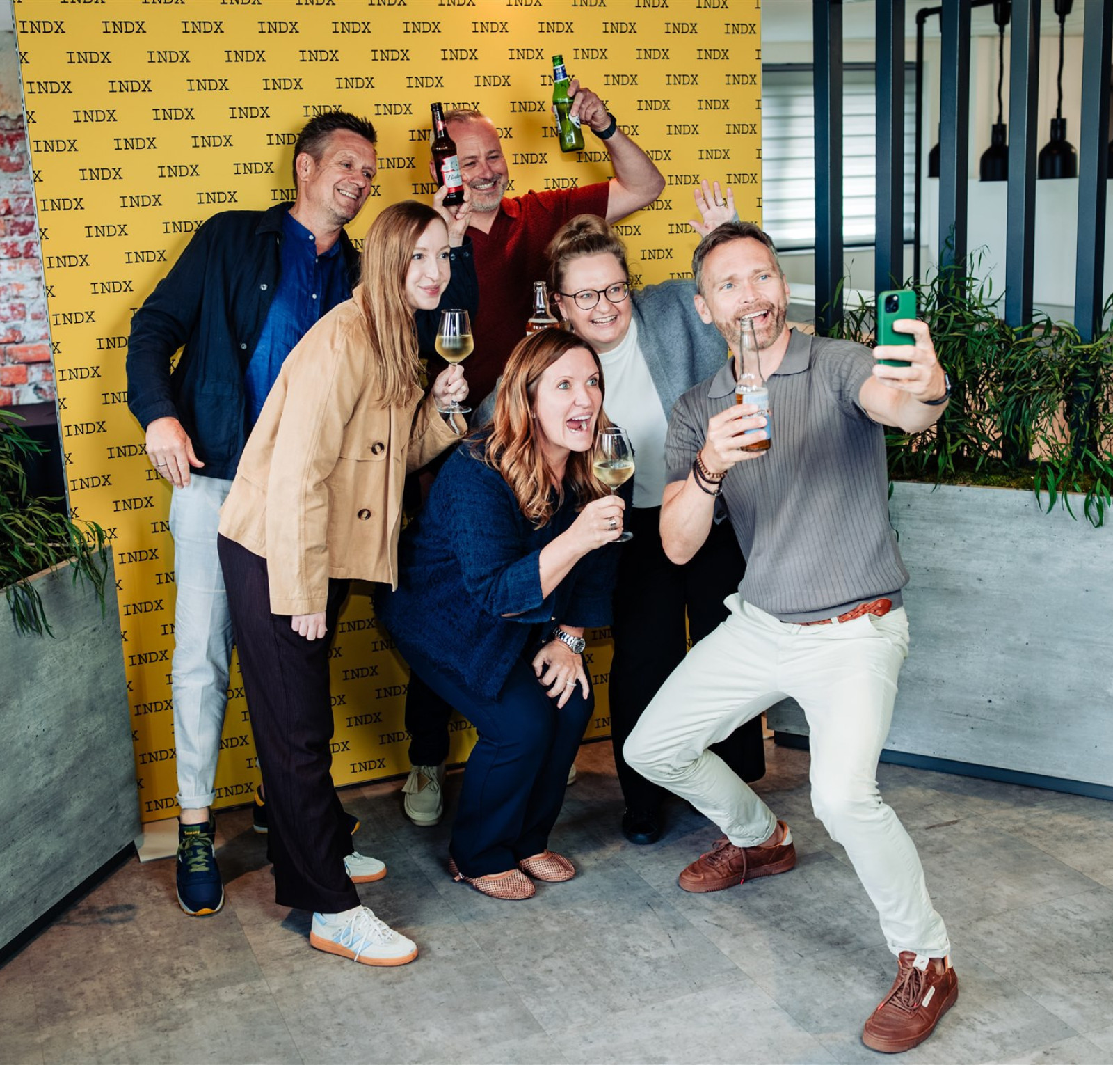 group of people taking a selfie in front of yellow backdrop