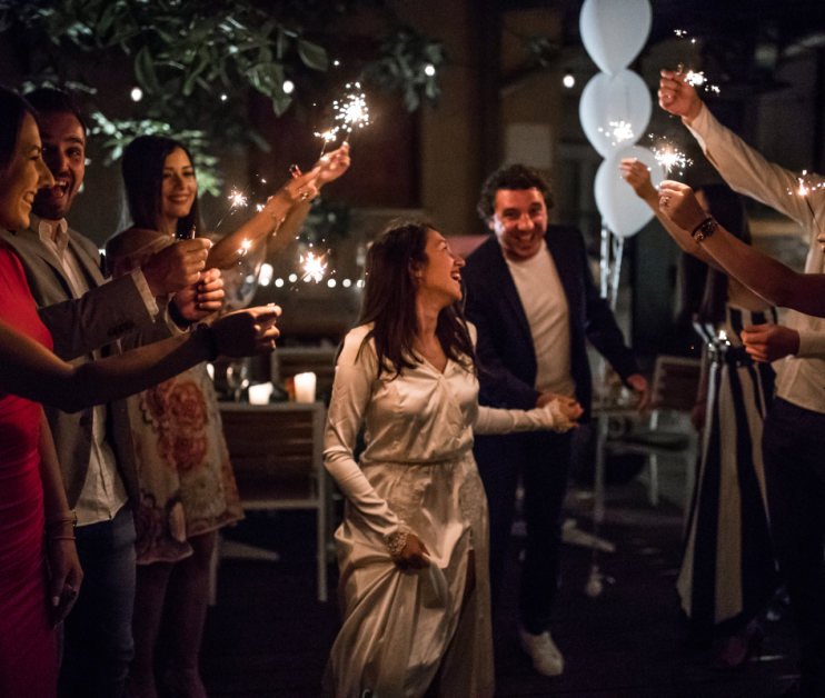 two people walking PAST PEOPLE WITH SPARKLERS