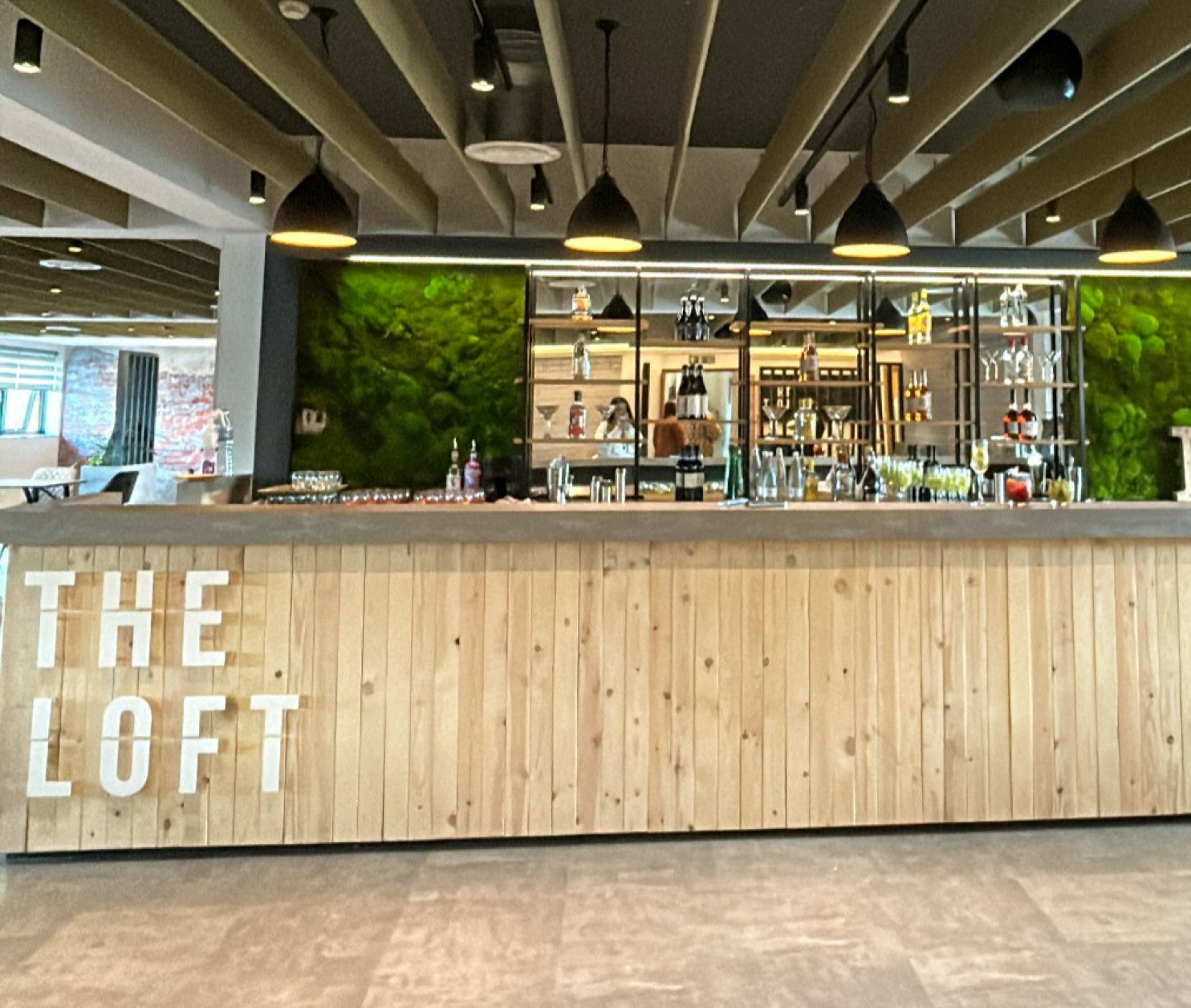 A stylish bar with a wooden counter displaying the name 