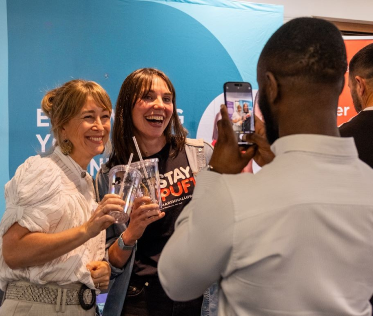 person taking a picture of two smiling people