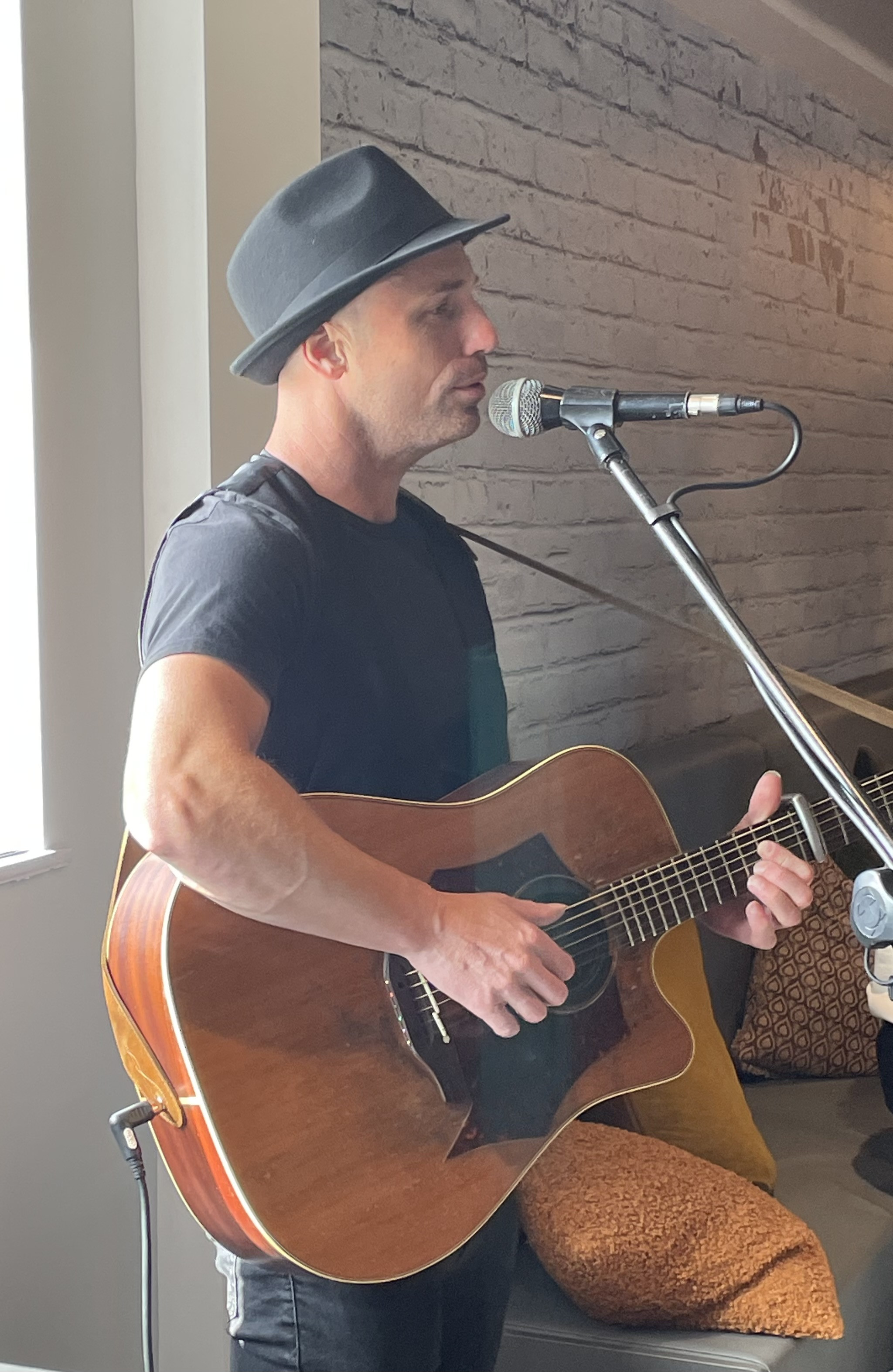 man playing guitar and signing into microphone