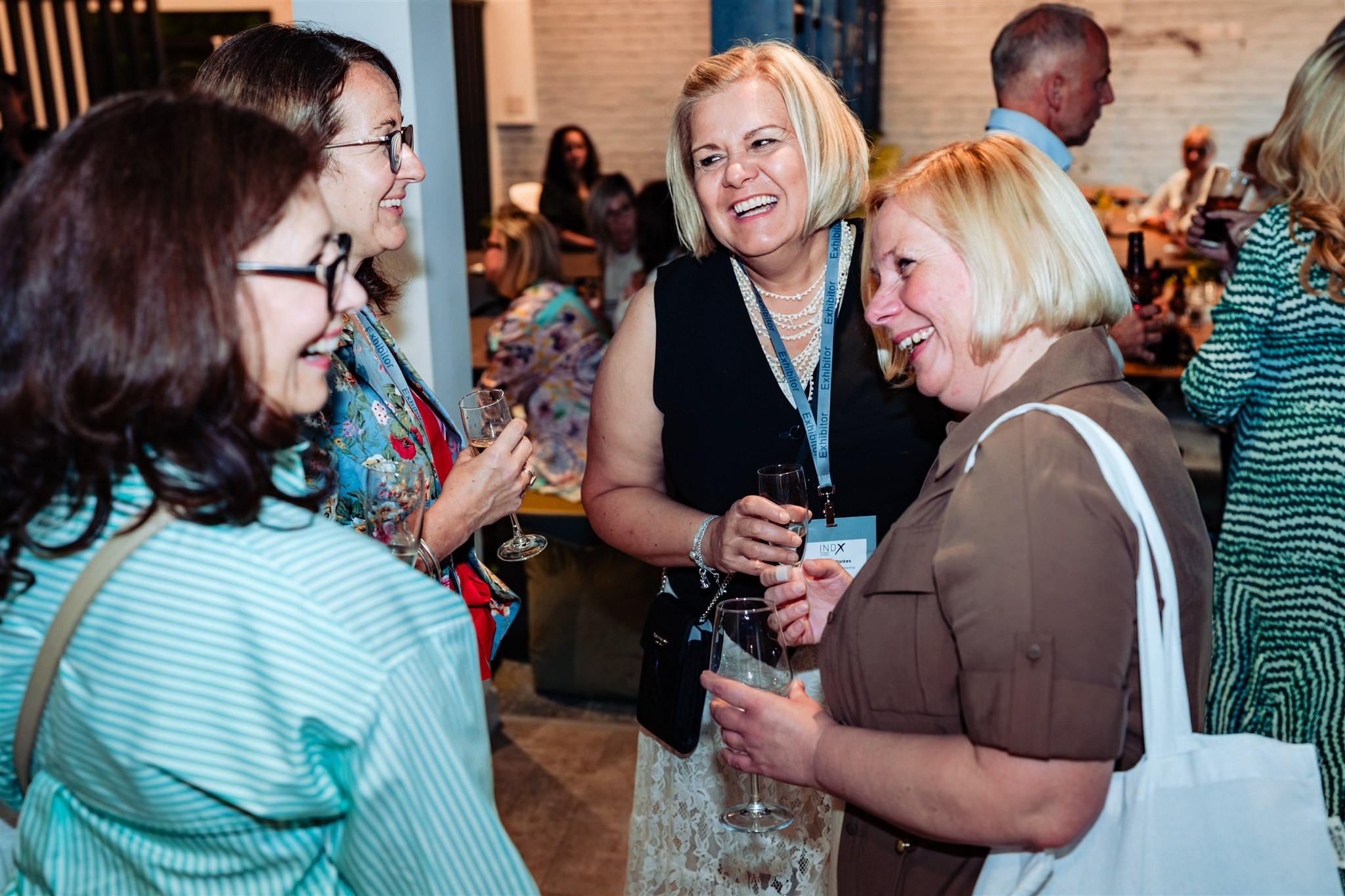 four ladies laughing at a drinks reception