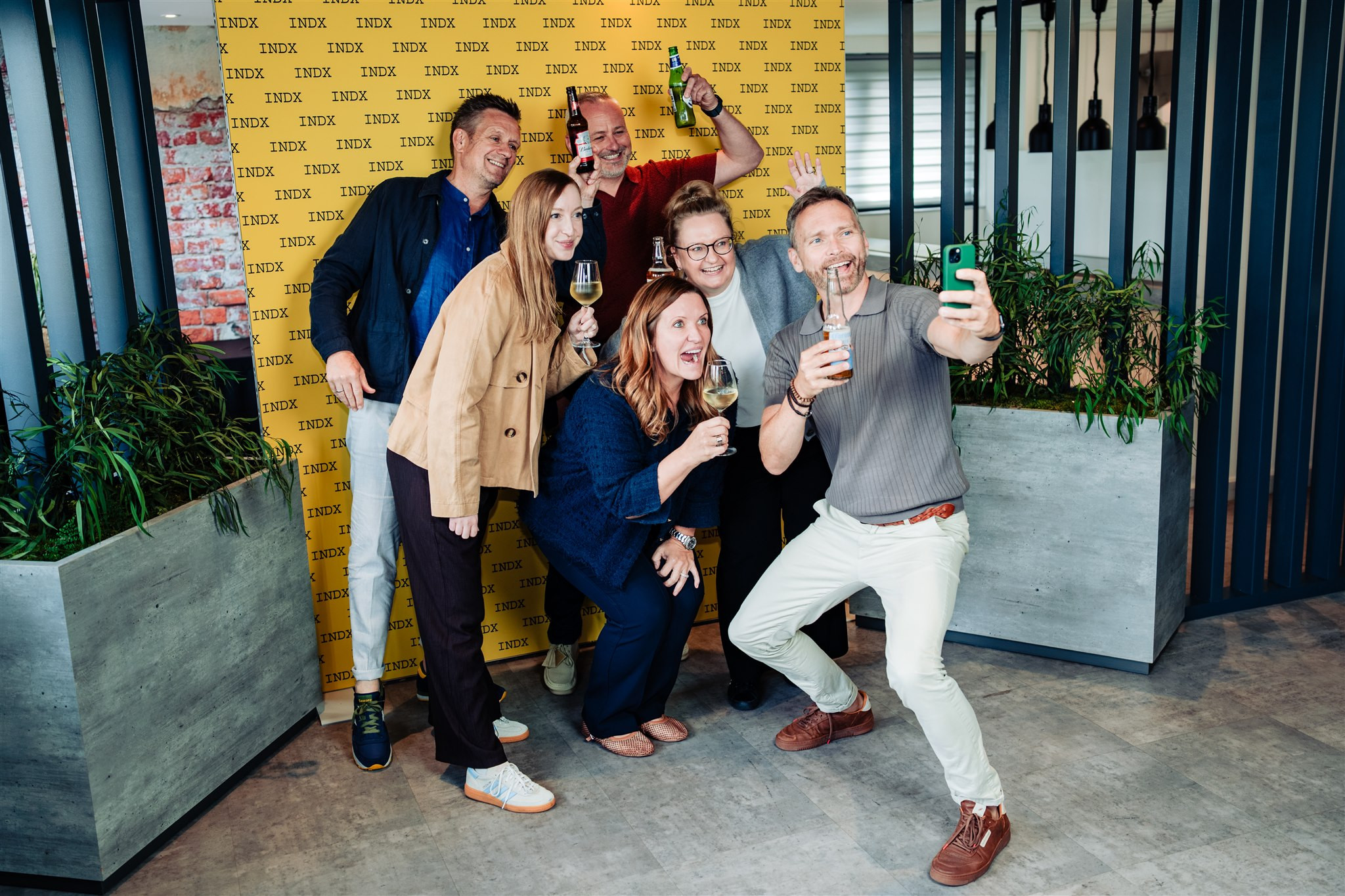 group of people taking a selfie in front of yellow backdrop